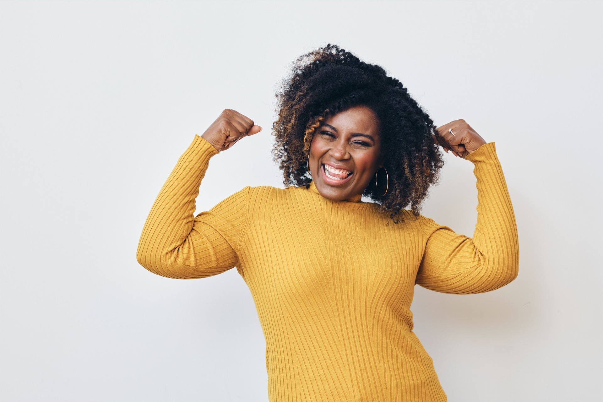 Femme fort gai fléchissant des muscles sur le fond blanc