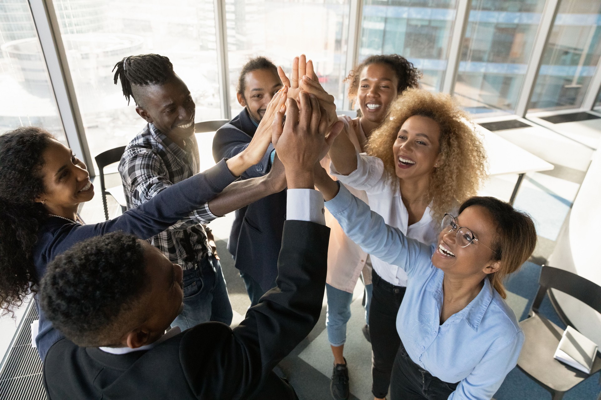 De jeunes collègues africains sympathiques se joignant dans l’air.